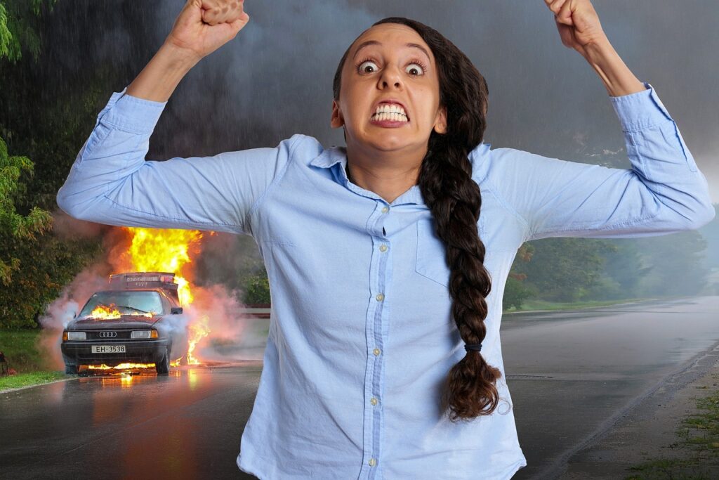 angry woman in a blue shirt, and an audi burning in the background