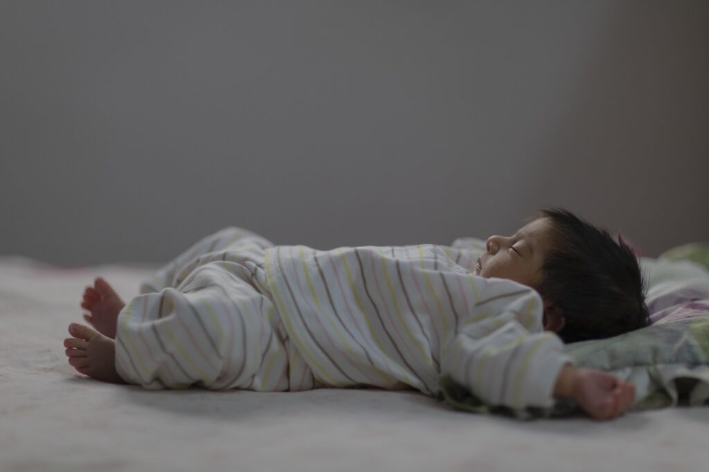 boy sleeping on his back for his Natural Anti-Aging Habits