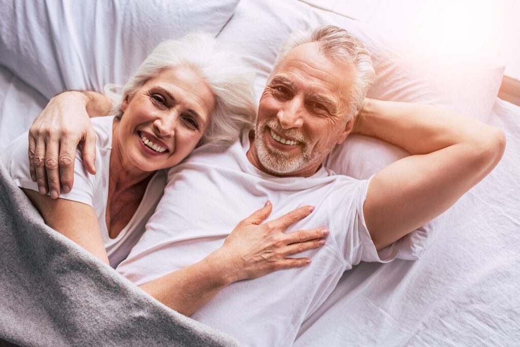 elderly people smiling in bed