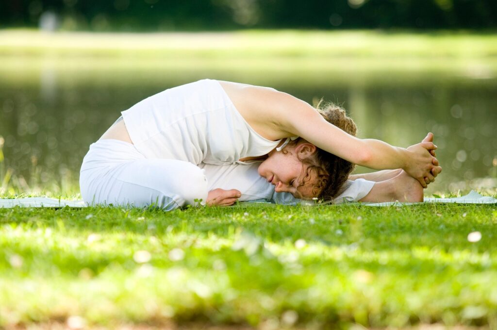 woman in white practicing yoga for her woman practicing deep sleep for her Natural Anti-Aging Habits