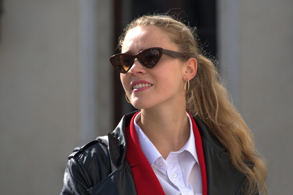 woman in a black jacket and black sunglasses