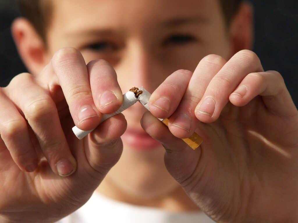 man breaking a cigarette in half