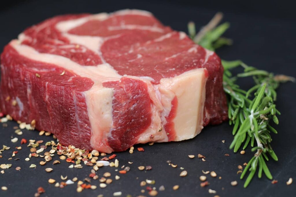 Fresh raw beef on a cutting board, rich in glycine and proline that help rebuild skin—collagen-boosting foods that make you younger.
