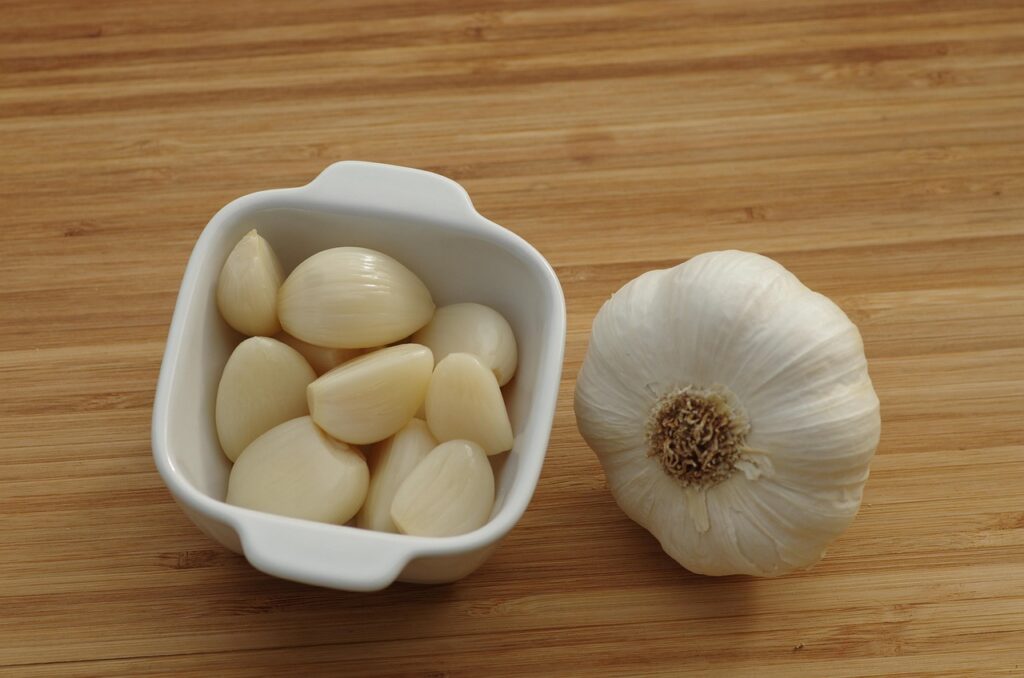 sliced garlic in a small dish and a full garlic