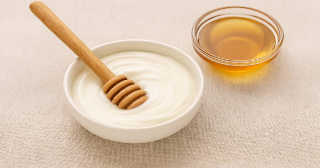 two cups one with yogurt, other one with honey - among the best dandruff natural remedies