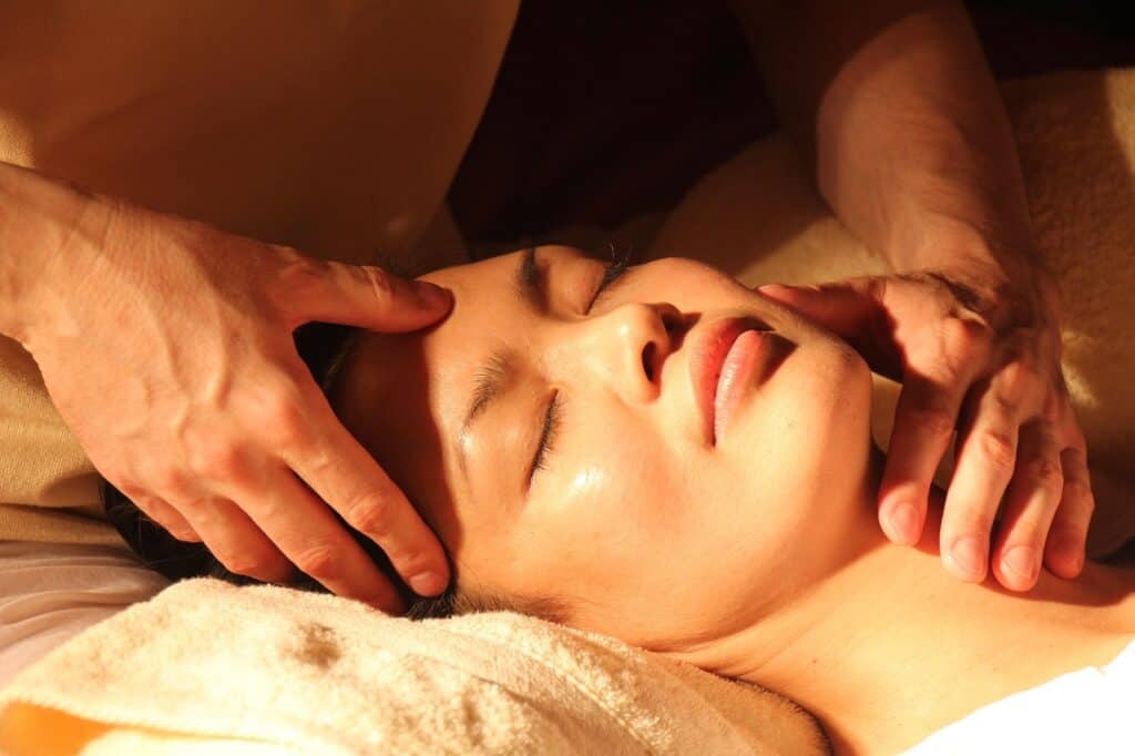 both-male-hands-massaging-woman's-face to keep skin young